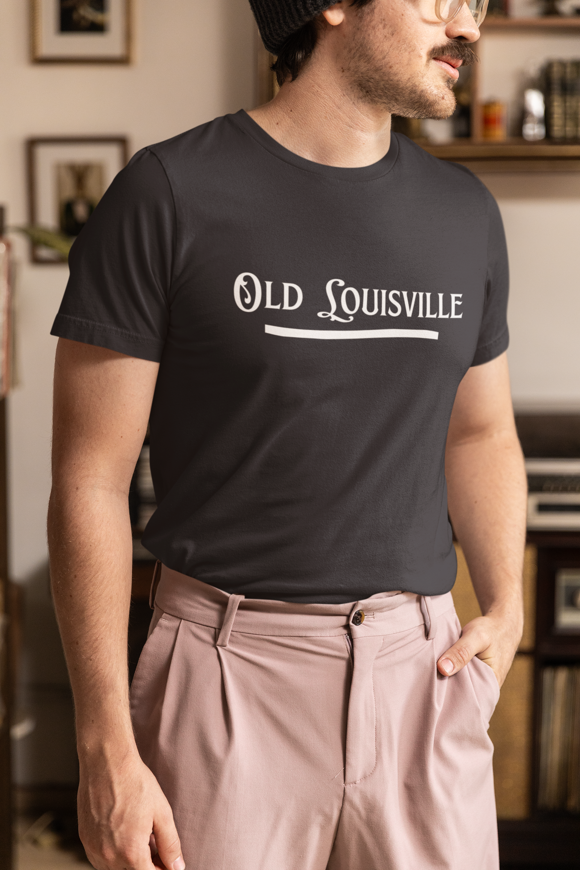 Man wearing a black t-shirt with 'Old Louisville' text in a room.