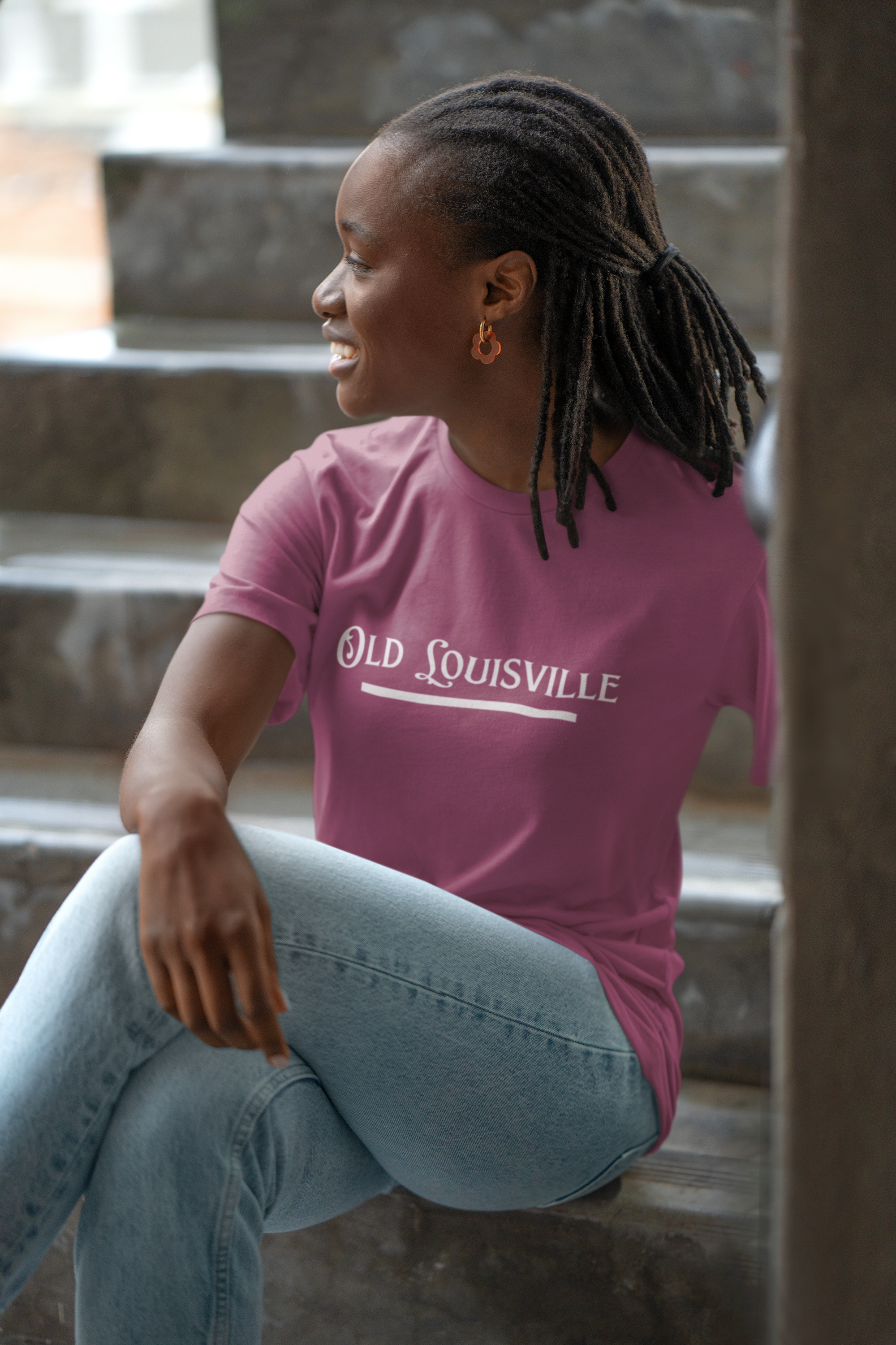 Person wearing a purple 'Old Louisville' t-shirt sitting on steps.